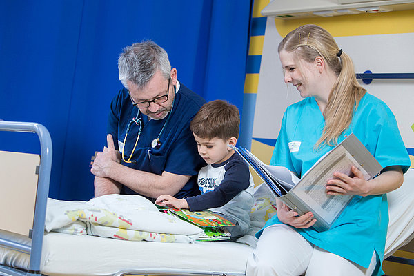 Krankenpflegerin und Krankenpfleger mit Kind
