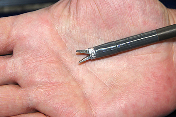 Die acht Millimeter messende Schere im Vergleich zur menschlichen Hand