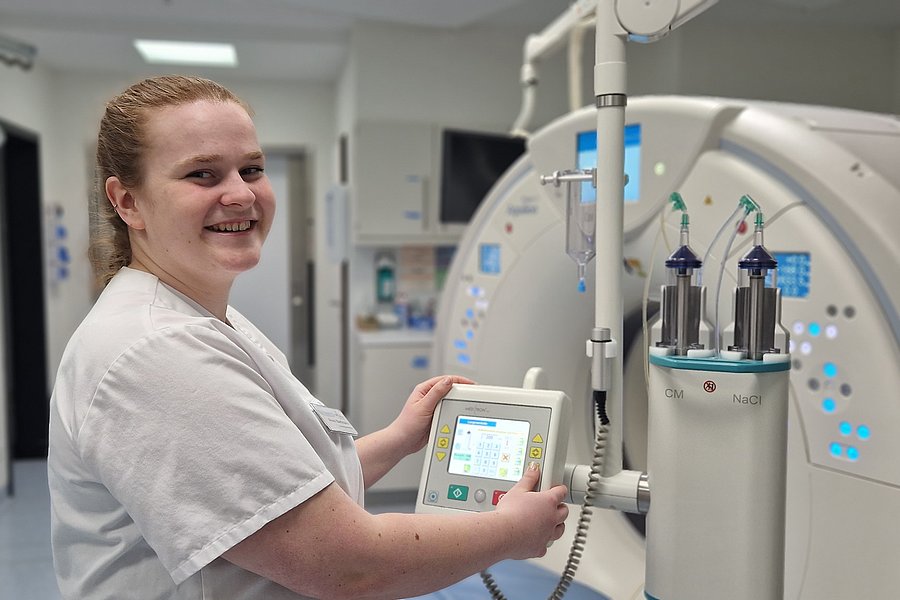 Eine Person in einem weißen Kittel bedient ein medizinisches Gerät mit einem Touchscreen. Das Gerät hat mehrere Zylinder und leuchtet blau.